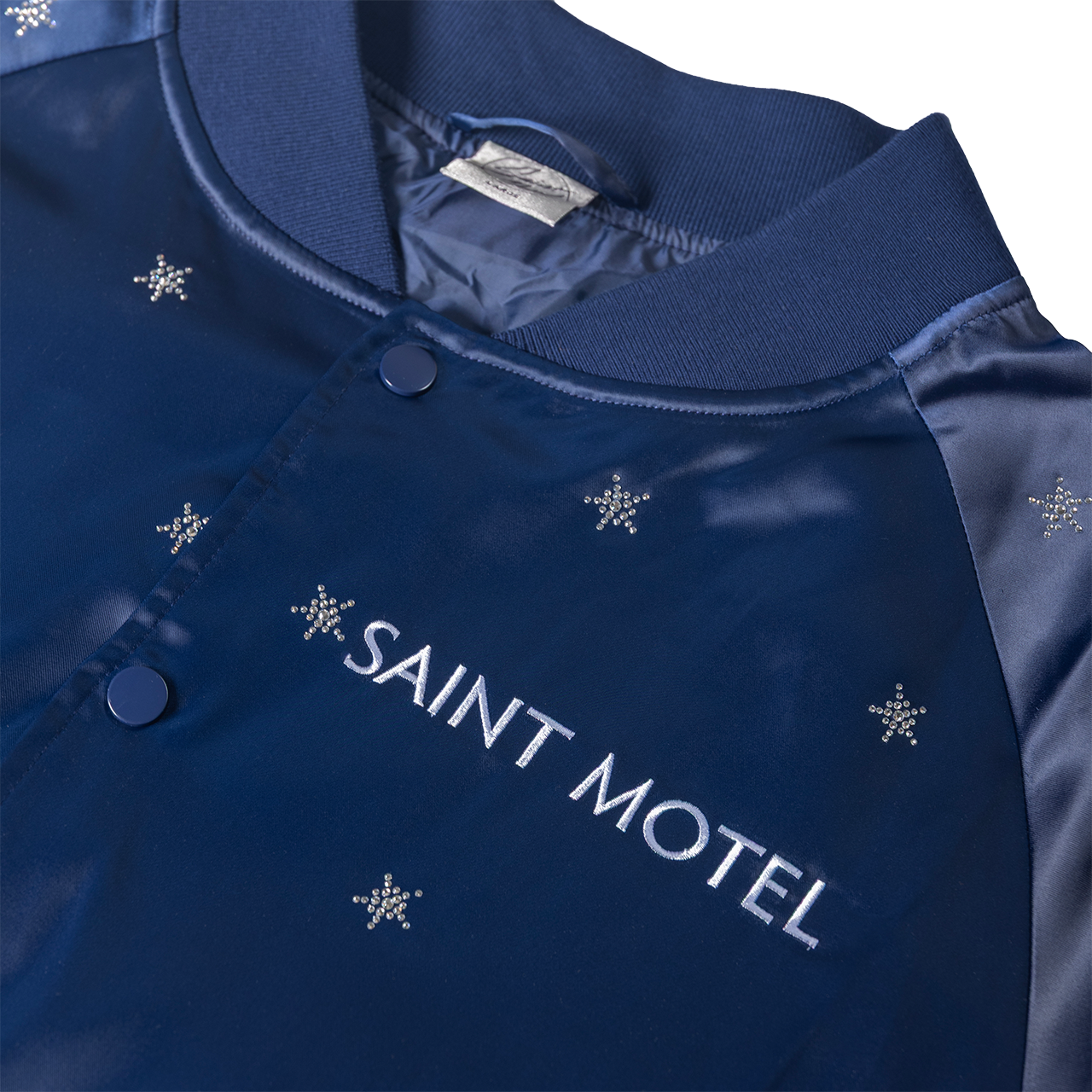 Blue jacket with 'Saint Motel' embroidery and snowflake patterns on a white background